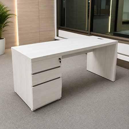 Escritorio ejecutivo en madera clara con cajonera lateral, superficie amplia y acabado moderno en oficina.