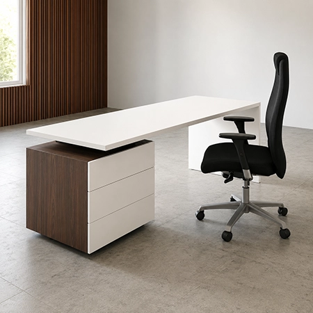Escritorio moderno blanco con cajonera lateral en tono nogal y silla ejecutiva negra en oficina minimalista.