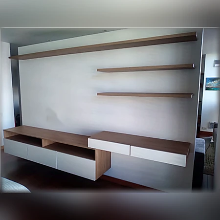 Centro de entretenimiento flotante en madera con repisas superiores y módulos blancos, de Muebles Dyeg.