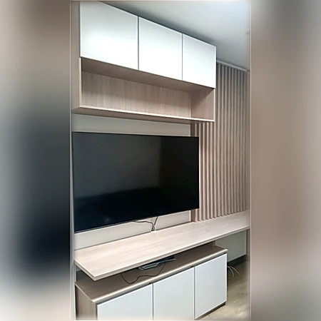 Centro de entretenimiento con gabinetes superiores blancos, panel decorativo y mueble inferior de madera, de Muebles Dyeg.