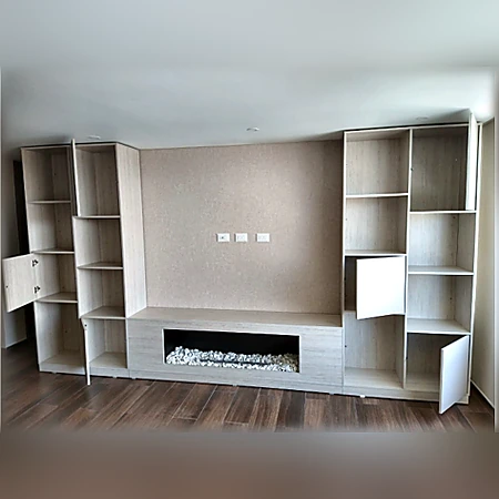 Centro de entretenimiento modular en tonos neutros con bibliotecas laterales y almacenamiento inferior, de Muebles Dyeg.